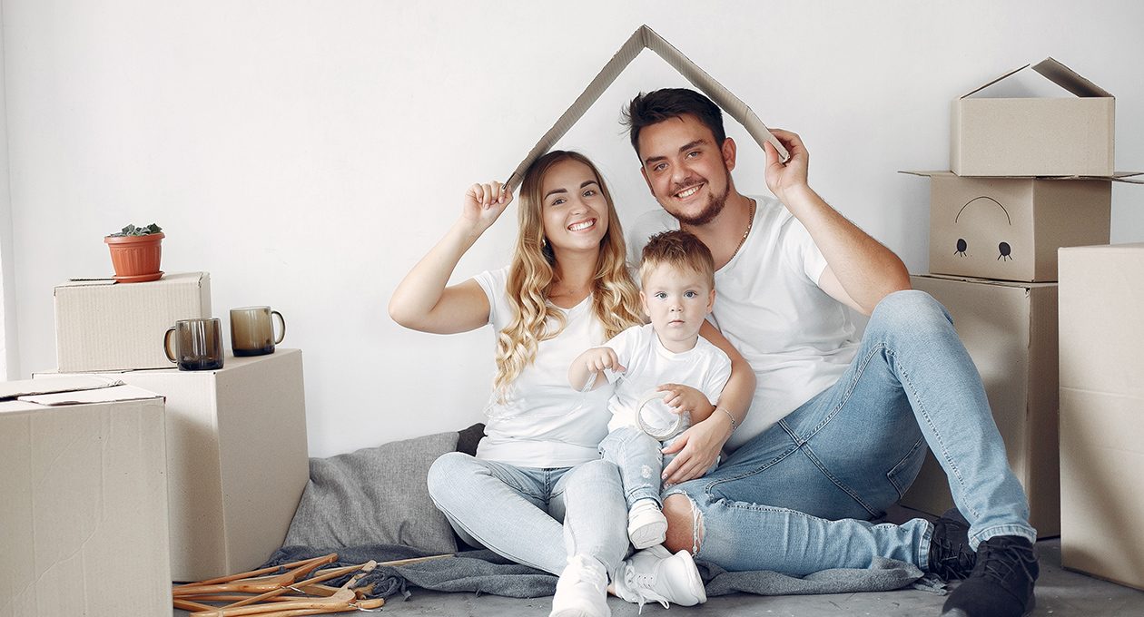 A family sitting together under a roof shape made with their hands